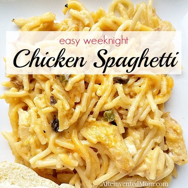 Easy Weeknight Chicken Spaghetti with a slice of bread on a white plate. A Reinvented Mom 